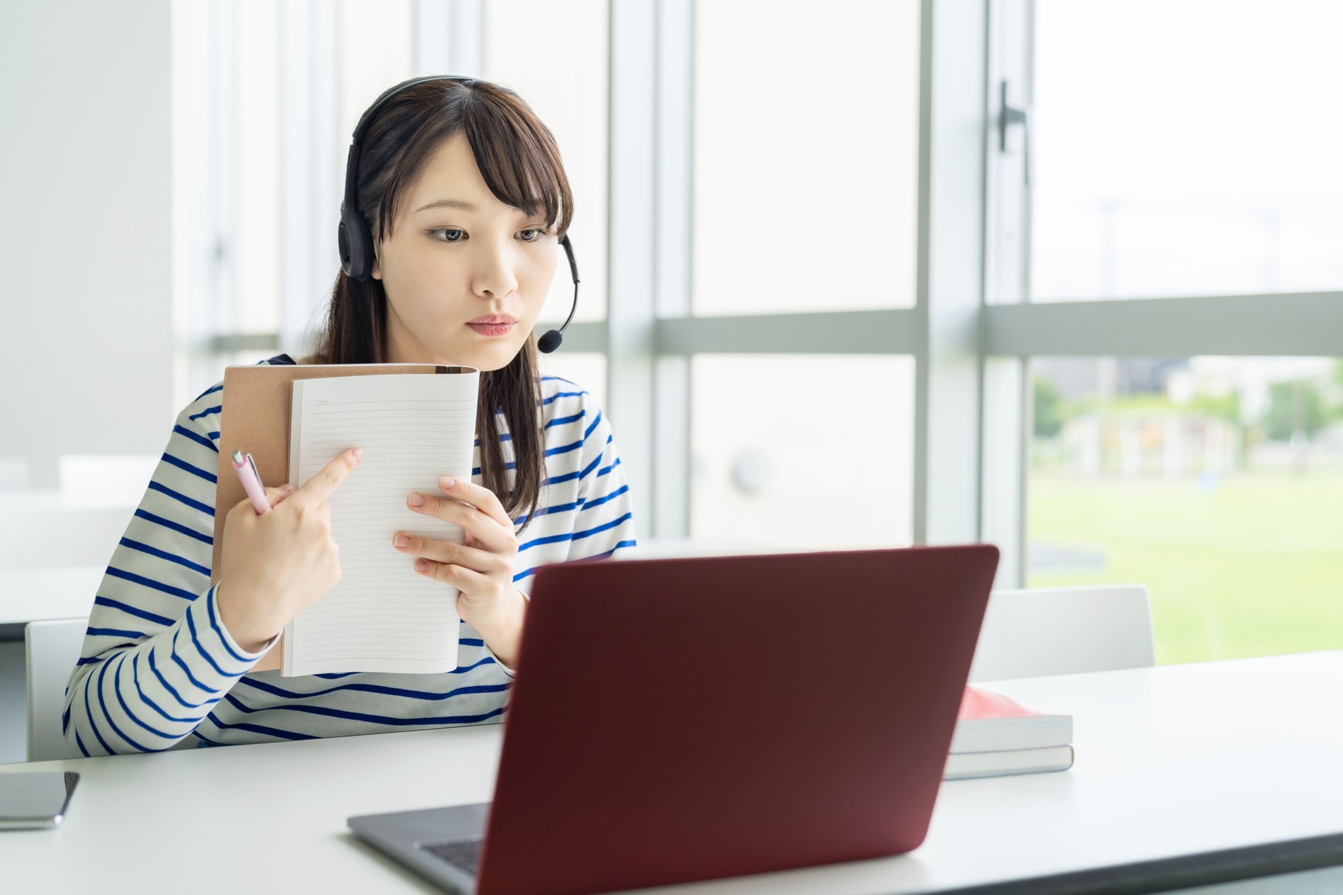 Asian female student taking online class. e-learning. Remote work.